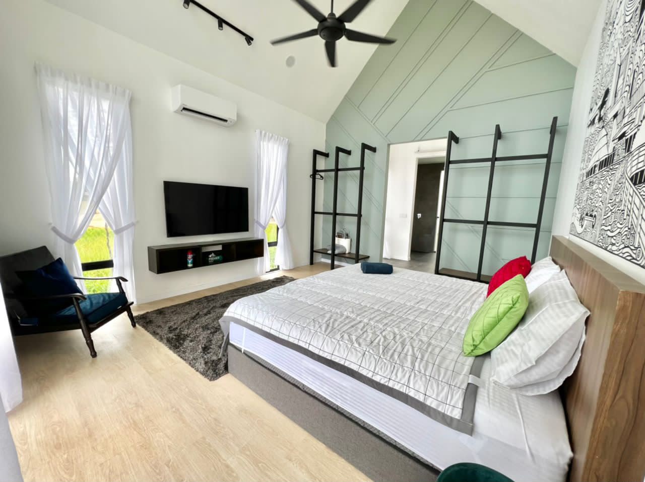 ASTA Suite at Ezu Isle Langkawi villa: king bed, 55-inch smart TV, armchair and open wardrobe racks against a mint feature wall