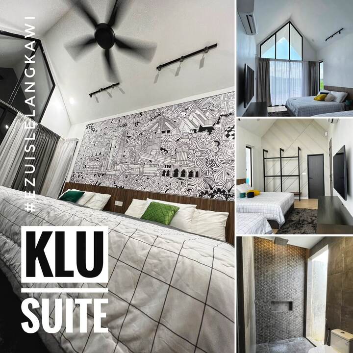 KLU Suite: twin beds beneath a Kuala Lumpur skyline mural, with rain shower bathroom