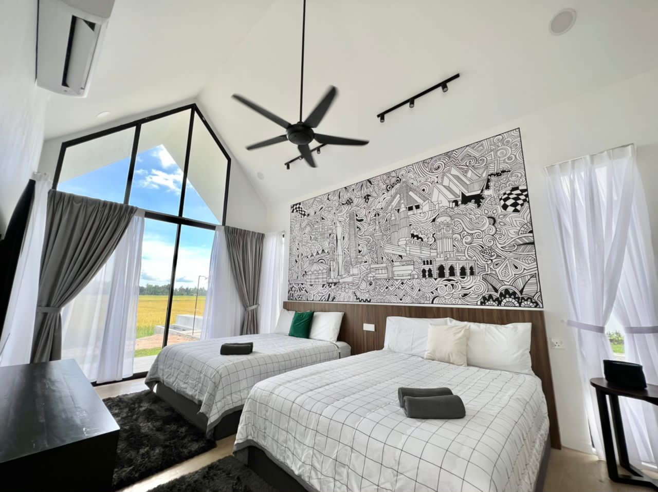 KLU Suite at Ezu Isle Langkawi villa with pool: two queen beds under a Kuala Lumpur skyline mural, glass gable facing the padi fields