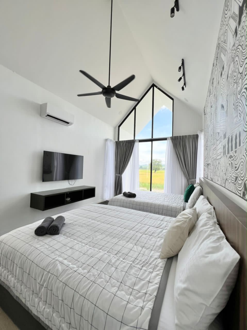 KLU Suite at Ezu Isle Langkawi villa: two queen beds facing a tall glass gable that looks out over the padi fields