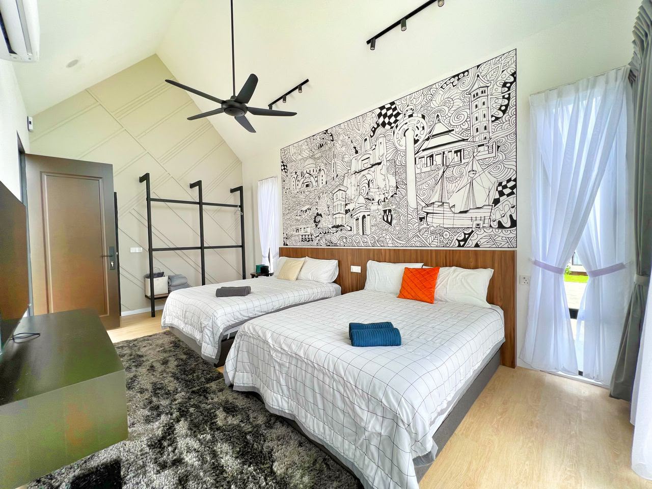 MYA Suite at Ezu Isle Langkawi villa: two queen beds under a hand-drawn Malaysian landmark mural, with open wardrobe racks